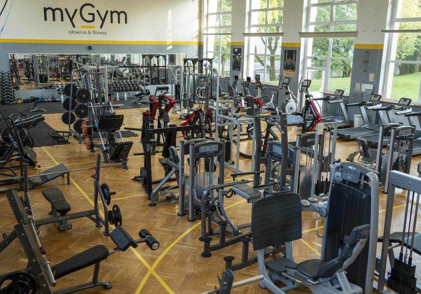 Szeroki plan hali treningowej z logo myGym na ścianie